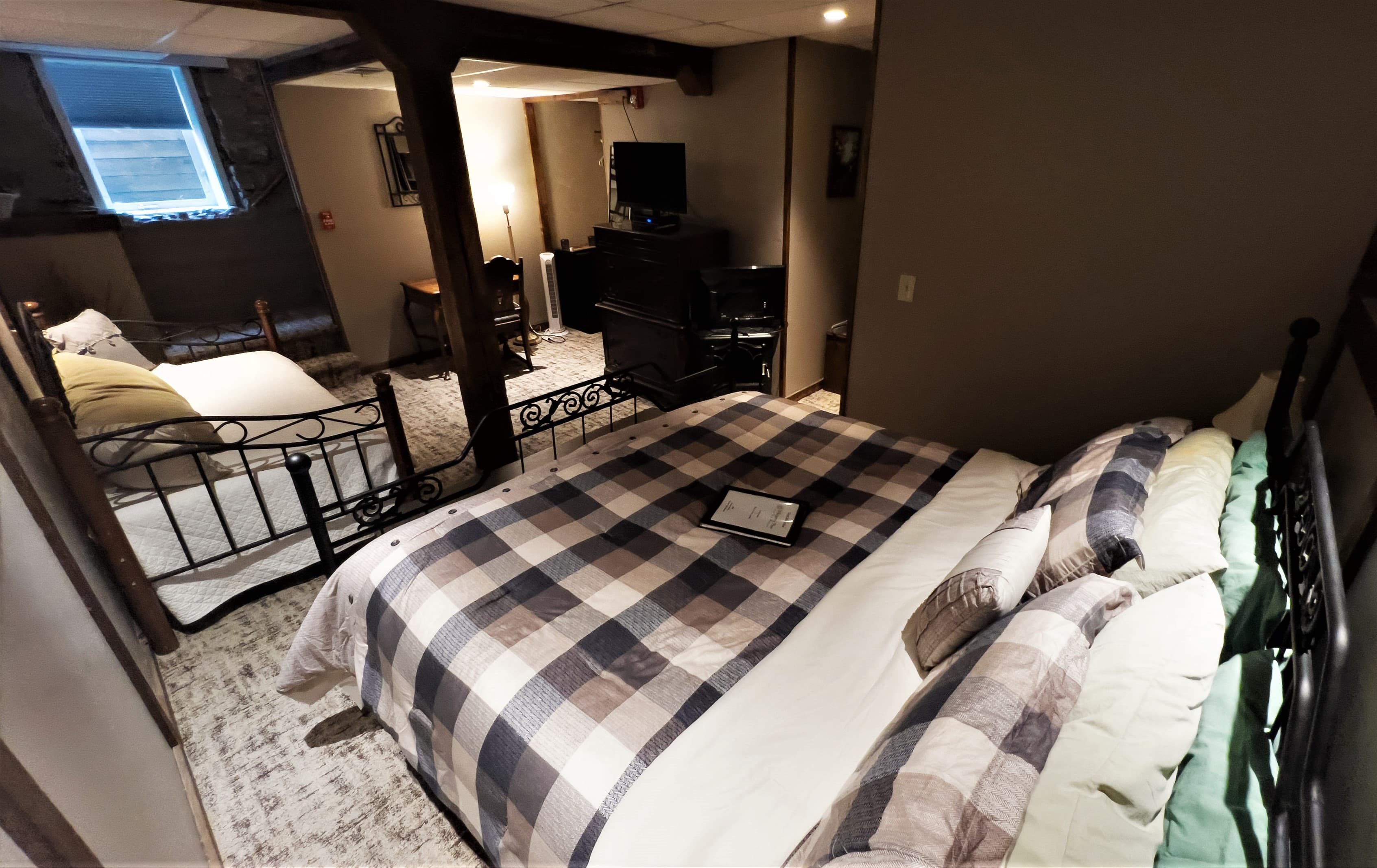 View of the guest room from the iron king size bed looking towards sitting area