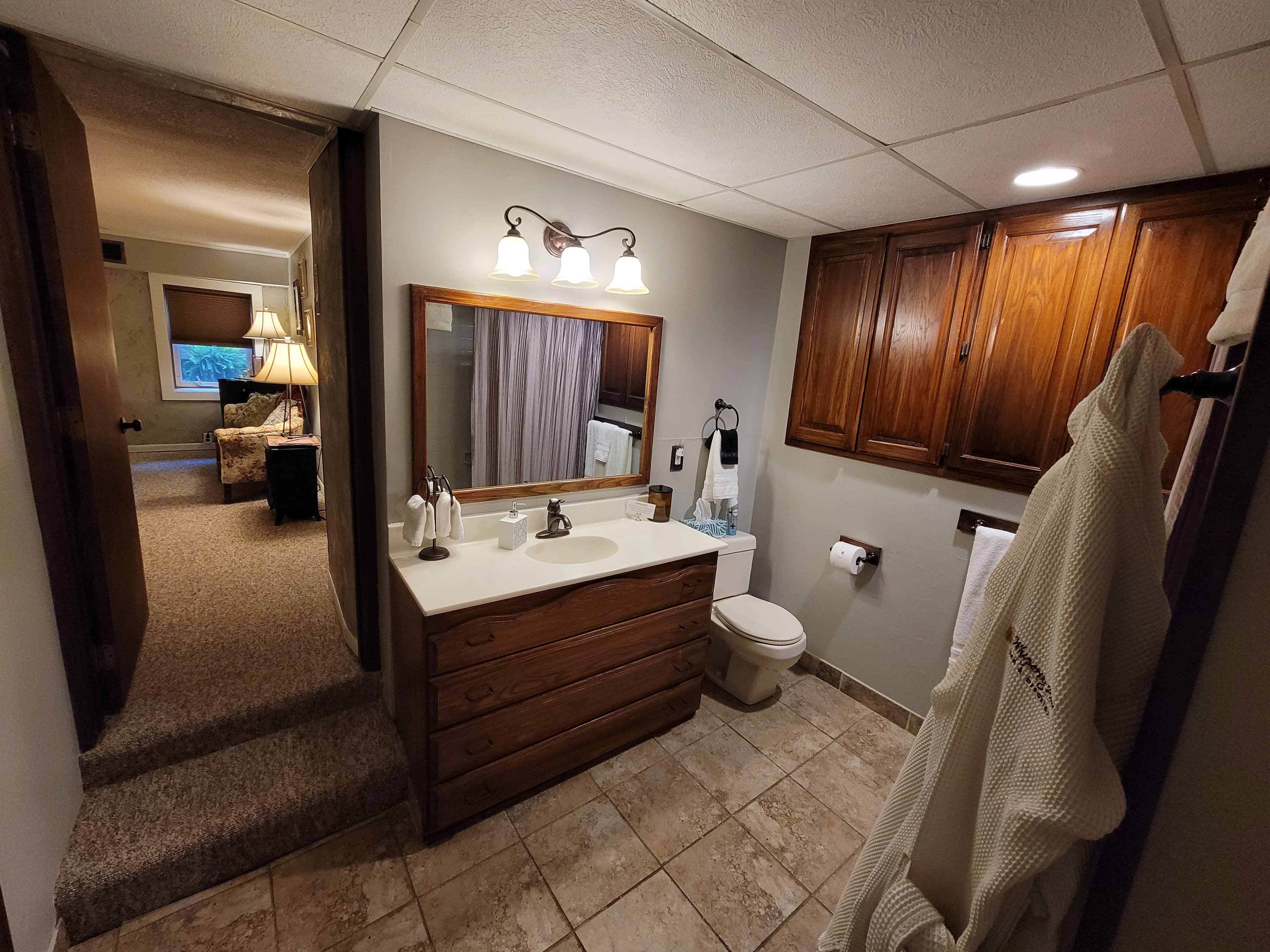 Spacious private bath with sink, toilet, heated tile floors, and combination shower/tub.