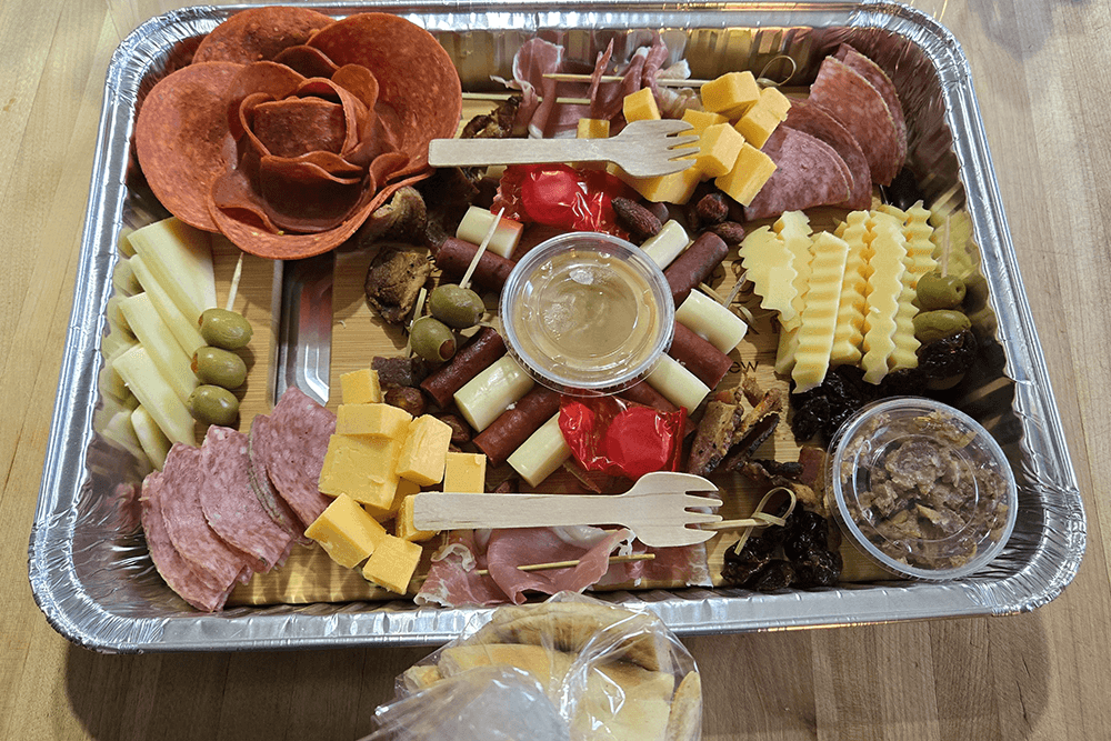 A vibrant charcuterie platter featuring assorted meats, cheeses, olives, and spreads.