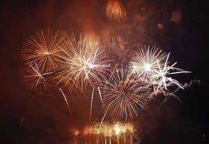 Colorful fireworks explode against a dark sky.