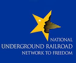 Logo of the National Underground Railroad Network to Freedom featuring a blue background and a star with a profile silhouette.