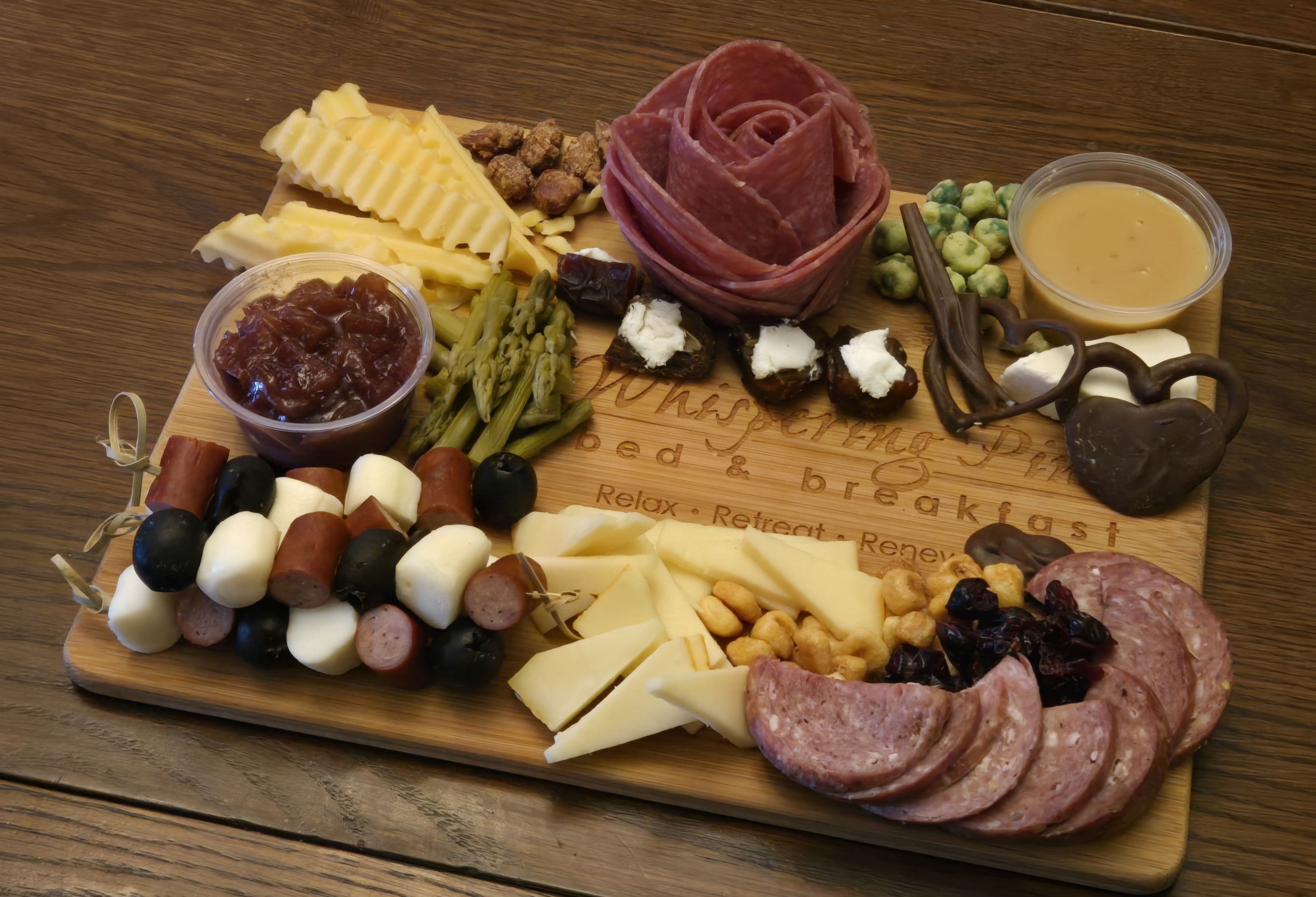 A beautifully arranged charcuterie board featuring various cheeses, meats, nuts, fruits, and accompaniments.